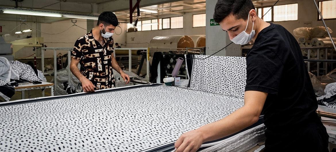 Homens trabalham em fábrica de tecidos na Turquia. 