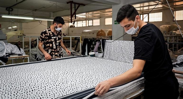 Homens trabalham em fábrica de tecidos na Turquia. 