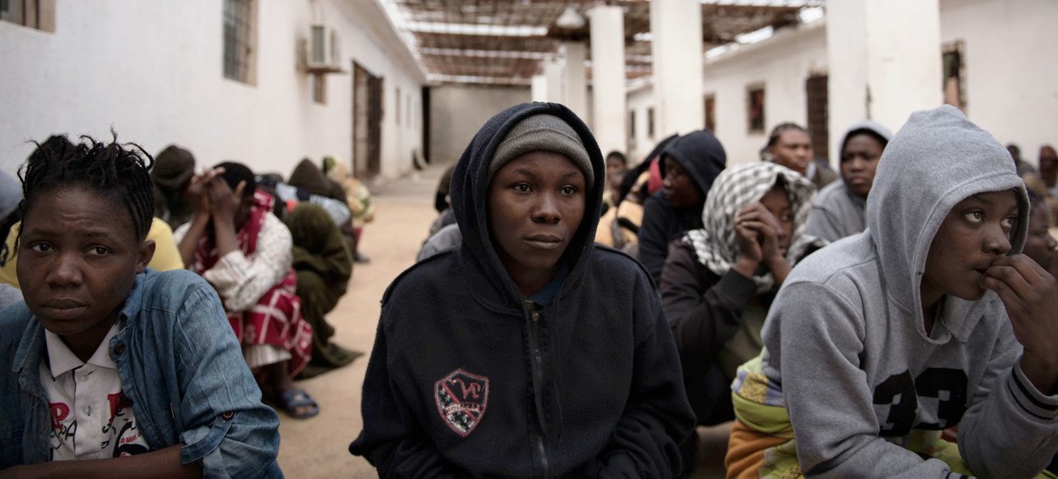 Des migrants originaires du Nigéria, qui ont été secourus par les garde-côtes libyens alors que leur bateau était en train de chavirer, sont accroupis dans la cour d'un centre de détention, où ils sont retenus, en Libye (archives)