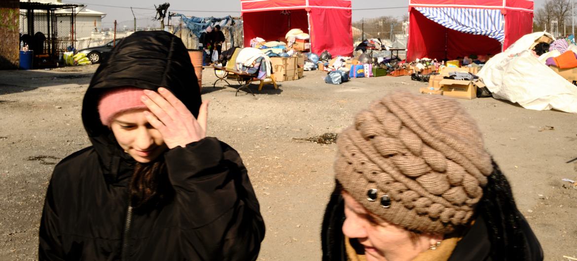 Mulheres ucranianas caminham em frente a tendas montadas em Medyka, na Polônia, para ajudar refugiados que fogem do conflito