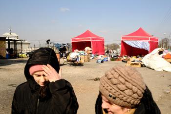 Mulheres ucranianas caminham em frente a tendas montadas em Medyka, na Polônia, para ajudar refugiados que fogem do conflito