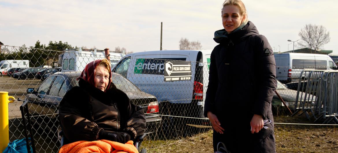 Des femmes ukrainiennes fuyant le conflit attendent un moyen de transport pour se rendre dans un centre de réfugiés en Pologne.