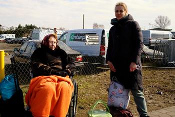 Des femmes ukrainiennes fuyant le conflit attendent un moyen de transport pour se rendre dans un centre de réfugiés en Pologne.