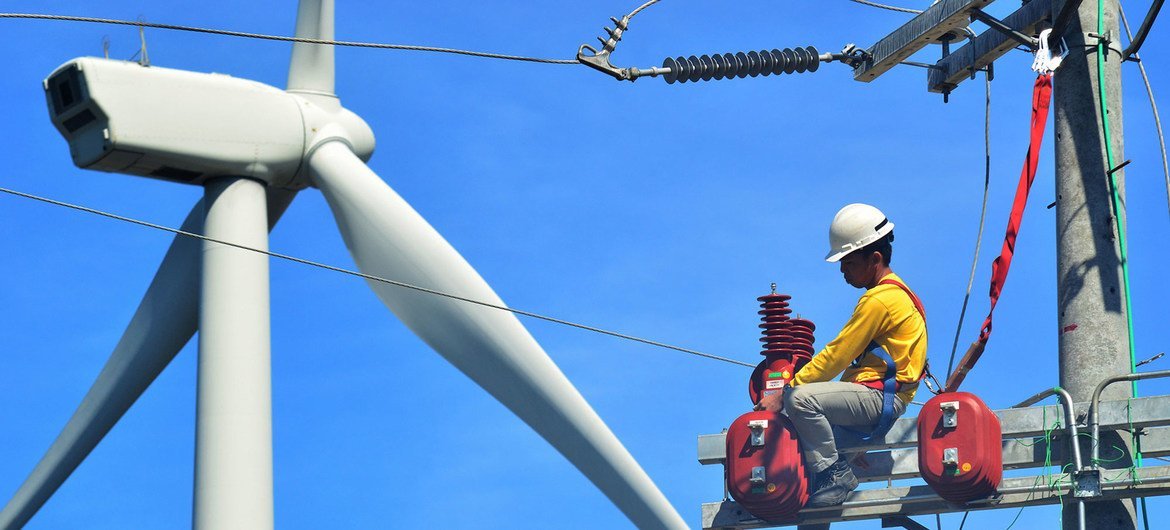 A technician works on a wind turbine in the Philippines.