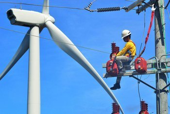A technician works on a wind turbine in the Philippines.