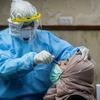 Un trabajador de salud hace la prueba del COVID-19 a un mujer en una clínica en Palestina.