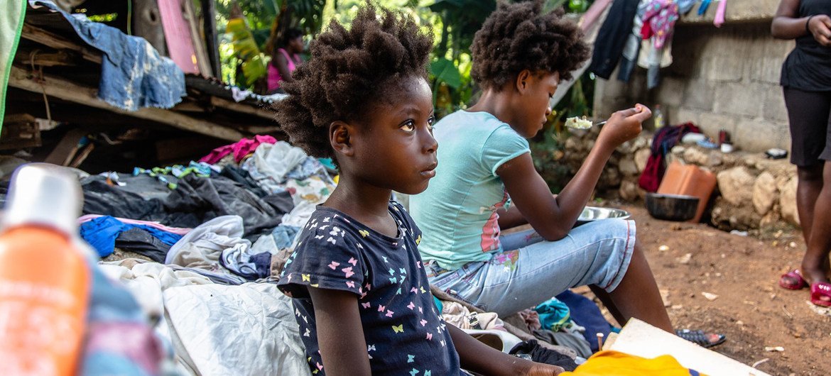 Family sits in the rubble of the house they lost in a 7.2 magnitude earthquake in Haiti.