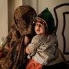 अफ़ग़ानिस्तान के कन्दाहार में, एक मेडिकल क्लीनिक में, एक महिला अपने बच्चे के साथ.