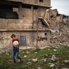 在伊拉克的摩苏尔老城，一个男孩拿着一个足球。