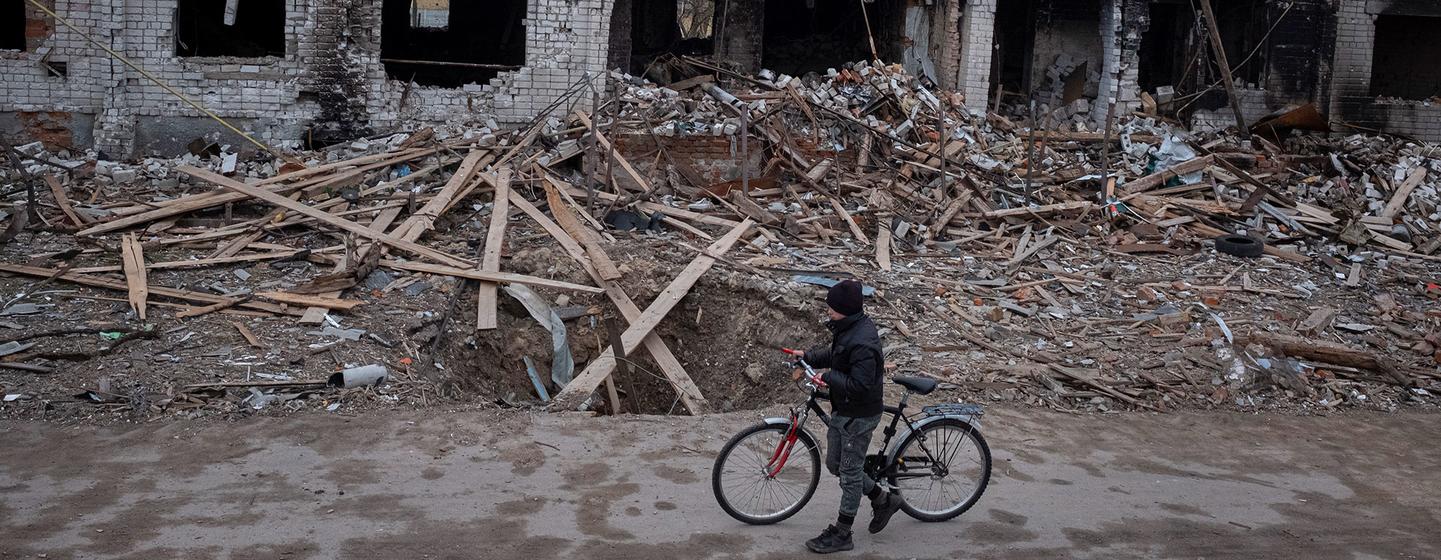 यूक्रेन के चरेनिहीफ़ में एक लड़का बमबारी में ध्वस्त हो चुके अपने घर के नज़दीक से गुज़र रहा है.