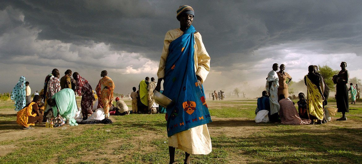 An elderly woman, internally displaced from her home in Abyei in Sudan, gets ready to receive her ration of emergency food aid.