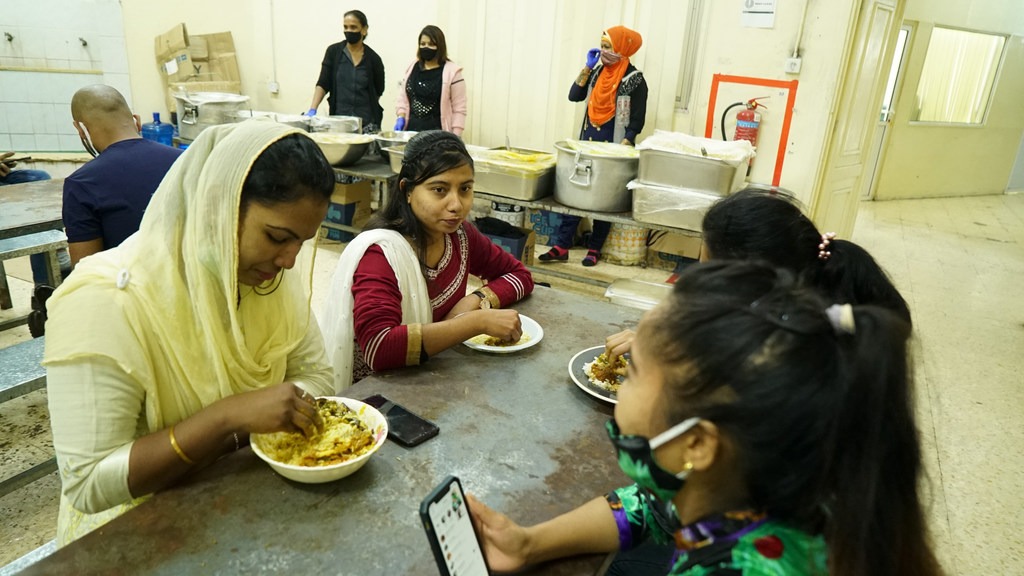 Maya Aktar comiendo con otras trabajadoras migrantes. 