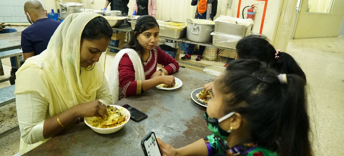 مایا آکتار در حال غذا خوردن با کارگران مهاجر.