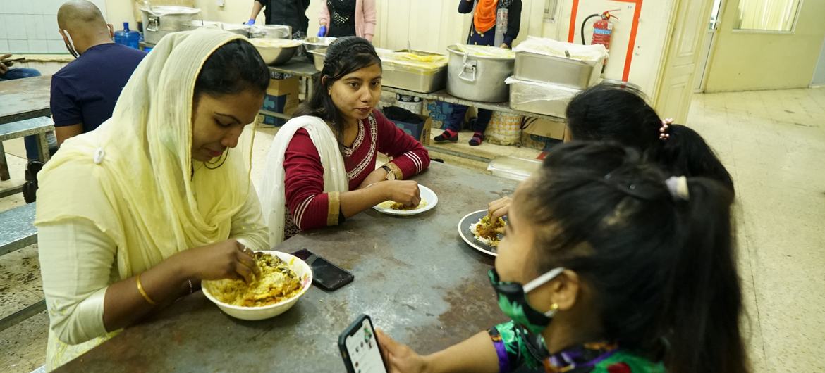 Maya Aktar eating with migrant workers.