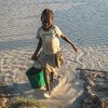 Un enfant porte de l'eau recueillie dans une mare artificielle dans le centre de Madagascar.