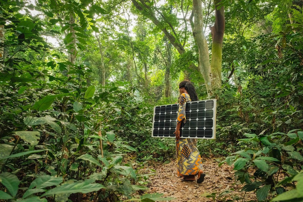 A Yangambi, dans le nord de la République démocratique du Congo, une femme transporte un panneau solaire