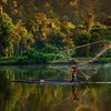 印度尼西亚的一名男子在森林湖泊里钓鱼。
