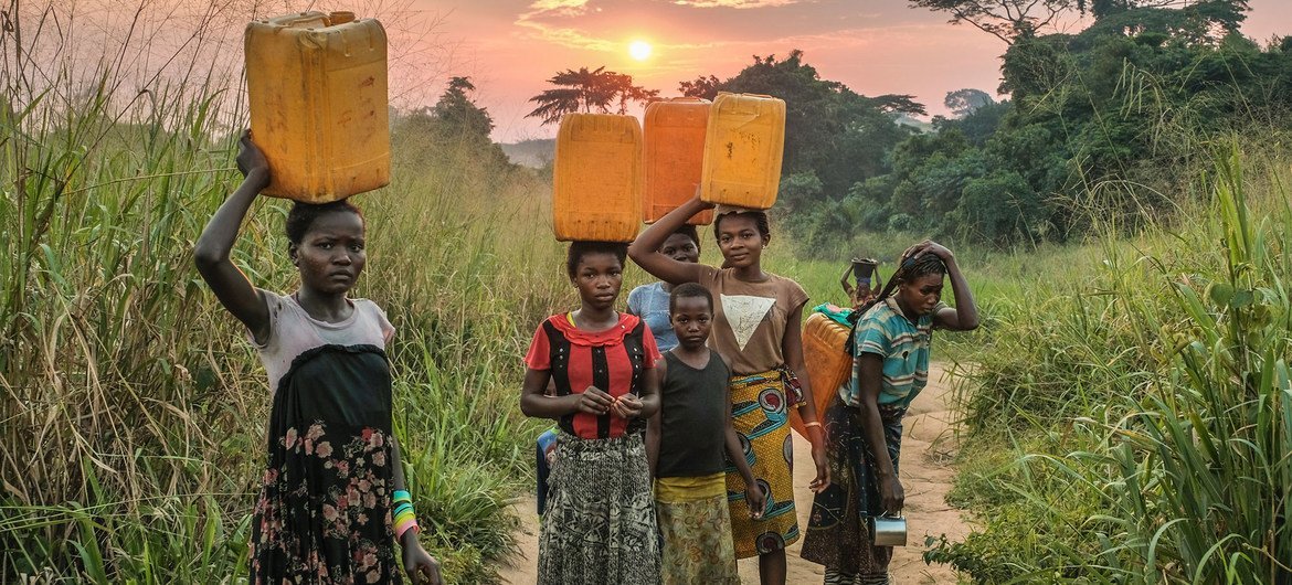 Unas niñas acarrean agua de una fuente cerca de Yangambi, República Democrática del Congo.