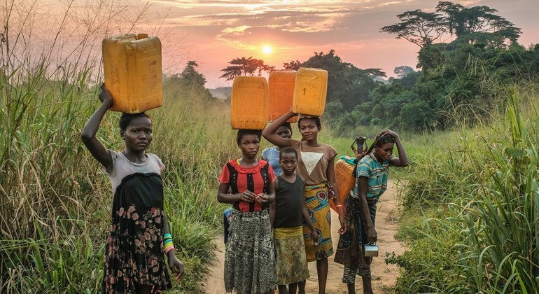 Young girls carry water from a source near Yangambi, Democratic Republic of the Congo.