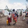 一位母亲和她的孩子走过刚果东部戈马的一处流离失所者营地。