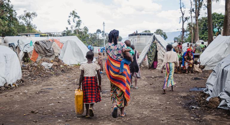 Uma mãe e seus filhos caminham por um campo para deslocados em Goma, leste da República Democrática do Congo