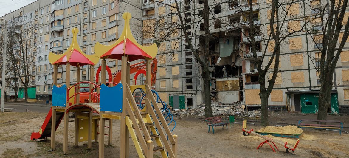 Parque infantil em frente a um edifício residencial fortemente danificado em Saltivka, Kharkiv (arquivo)