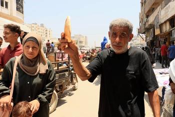 Gaza resident Ahmed Al-Bahri holds up a loaf of bread.
