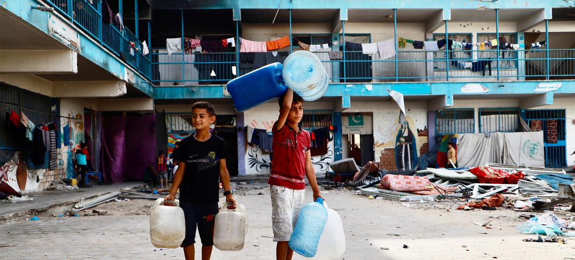 Children at an UNRWA school shelter in Khan Younis, southern Gaza, on their way to fetch water.