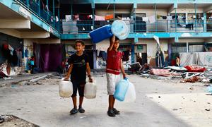 Children at an UNRWA school shelter in Khan Younis, southern Gaza, on their way to fetch water.