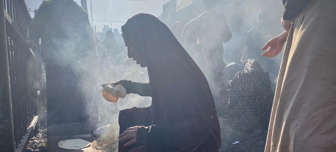 Палестинцы, покинувшие свои дома, готовят пищу возле центра БАПОР в центральной Газе.