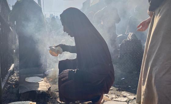 Палестинцы, покинувшие свои дома, готовят пищу возле центра БАПОР в центральной Газе.
