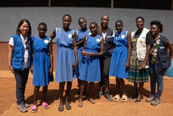 Deborah Nguyen (à gauche) chargée de la communication au bureau du PAM pour l'Afrique de l'Est pose avec du personnel du PAM et des étudiants à l'école primaire de Kangole, Karamoja, Ouganda. 