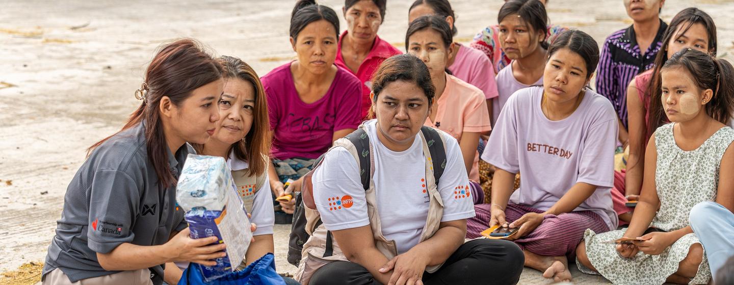 At the emergency relief item distribution, UNFPA staff introduces the content of the dignity kits and provides information on gender-based violence for earthquake- affected women and girls in Mandalay, Myanmar.