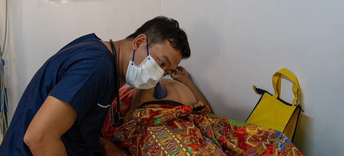 UNFPA द्वारा समर्थित एक मोबाइल क्लीनिक में एक महिला की प्राथमिक स्वास्थ्य जाँच की जा रही है.