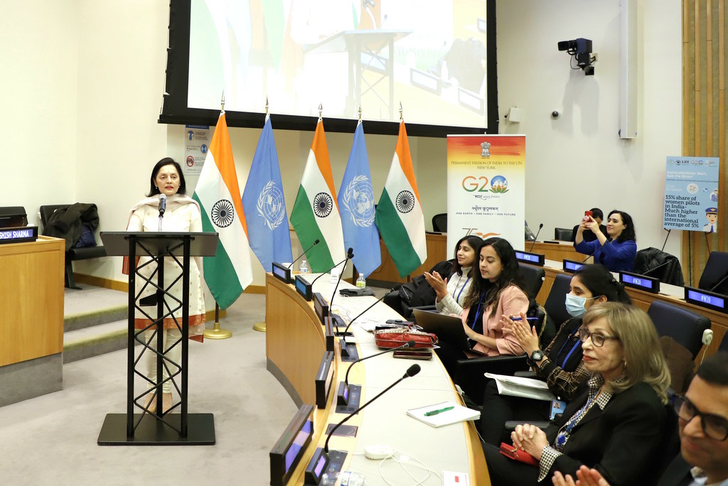 भारत की स्थायी प्रतिनिधि, राजदूत रुचिरा कंबोज, न्यूयॉर्क में CSW67 के साइड इवेंट के दौरान एक मंच पर भाषण दे रही हैं। उनके पीछे भारतीय और UN के झंडे प्रदर्शित हैं, और सम्मेलन कक्ष में श्रोता बैठे हैं।