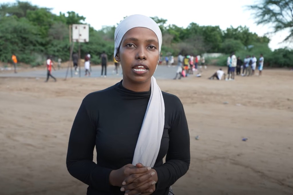 Saido Omar Noor, mkimbizi wa Somalia mwenye umri wa miaka 25, amesimama katika uwanja wa mpira wa vikapu katika makazi ya Kakuma nchini Kenya.