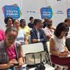Participantes do Fórum da Juventude da África Ocidental e do Sahel em Mindelo, Cabo Verde, assistindo a uma apresentação.