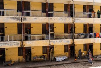 Vista interior de um prédio amarelo de três andares em Wad Madani, Sudão, que abriga milhares de deslocados internos que fugiram do conflito em Cartum.