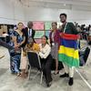 समोआ के एडिलेड नफोई (बाएँ से दूसरे) समेत, SIDS वैश्विक बाल एवं युवा कार्रवाई सम्मेलन के प्रतिनिधि, "संकल्प दीवार" का अपना हिस्सा पूरा करने के बाद.