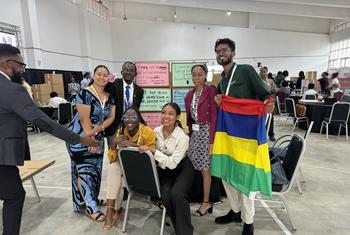 Les délégués au Sommet mondial d'action pour les enfants et les jeunes des PEID, dont Adelaide Nafoi de Samoa (deuxième à partir de la gauche), après avoir terminé leur section du « mur d'engagement ».