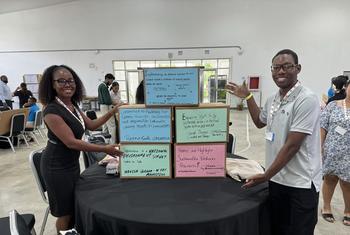 SIDS Global Children and Youth Action Summit delegate Renee Smith (left) after completing her section of the “wall of commitment” to be presented to the SIDS4 conference.