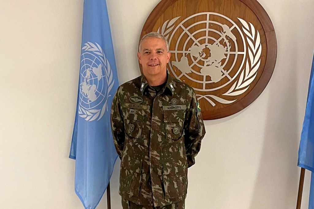 Ulisses de Mesquita Gomes, Kamanda mpya wa Jeshi la MONUSCO, amesimama akiwa amevaa sare za kijeshi mbele ya nembo UN na bendera.