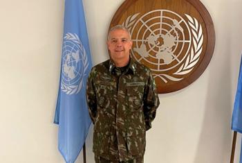 Ulisses de Mesquita Gomes, Kamanda mpya wa Jeshi la MONUSCO, amesimama akiwa amevaa sare za kijeshi mbele ya nembo UN na bendera.