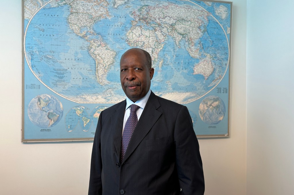 Leonardo Santos Simão, Representante Especial da UNOWAS, posa para um retrato profissional em frente a um mapa-múndi.
