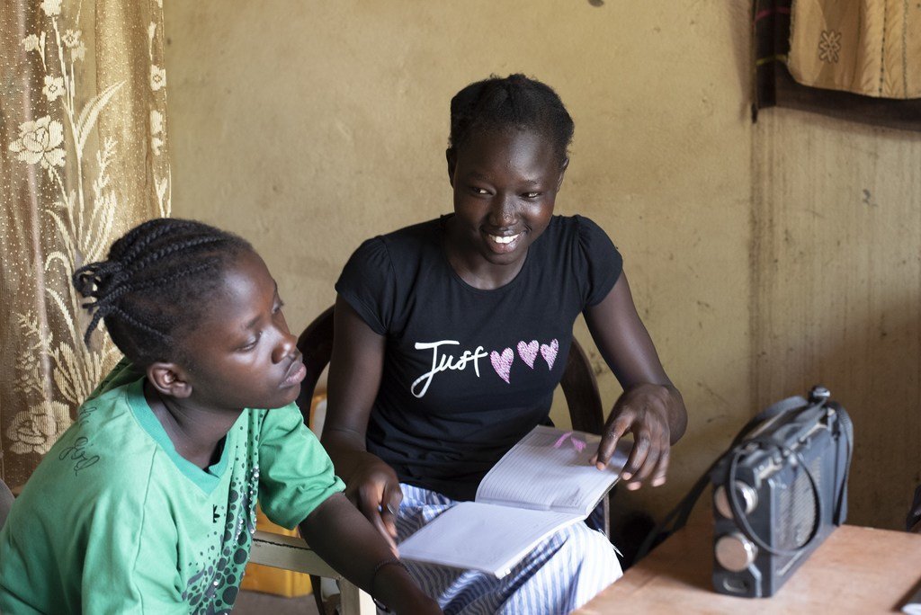 Dos jóvenes escuchando la programación educativa de Radio Miraya, en Sudán del Sur.