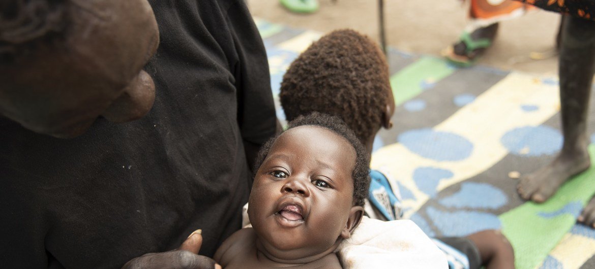 باتي كوجو يداعب ابنته الصغرى غول في مركز تغذية في بيبور، جنوب السودان