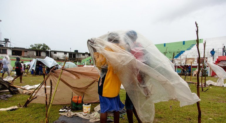 Les habitants des Cayes, déplacés par le tremblement de terre de magnitude 7,2 du 14 août 2021, s'abritent de la dépression tropicale Grace sous une bâche en plastique sur le terrain de football du Stade des Gabio. 