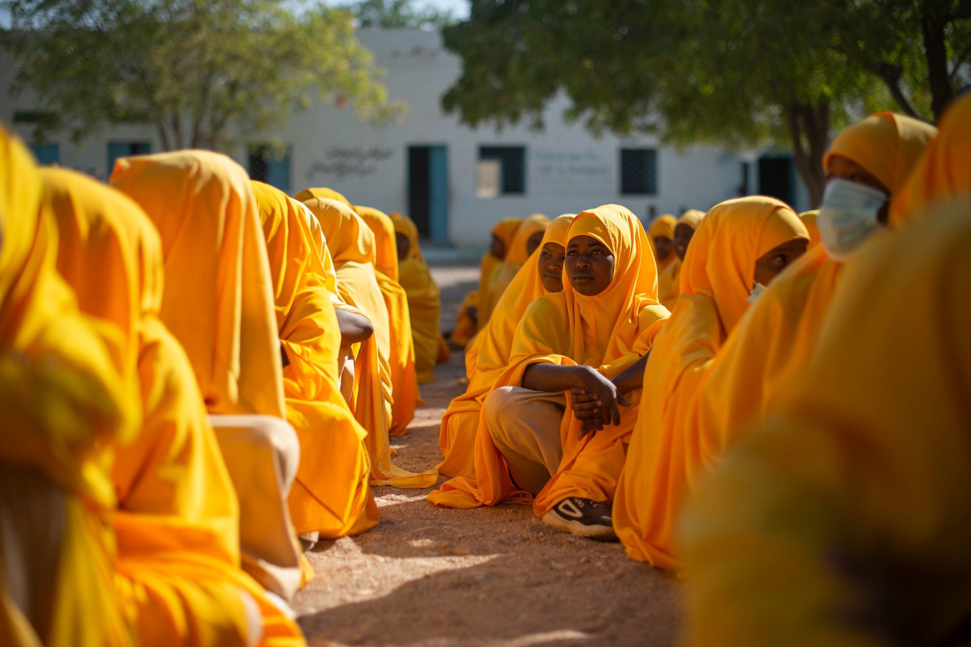 Kundi la wasichana wa shule wa Kisomali waliovaa hijabu za njano wakiwa wameketi katika ua wa shule wakati wa mkutano huko Garowe, Puntland, Somalia.