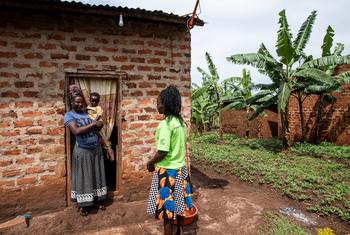 فيونا التي تعمل كأم نظيرة في مركز Rugaga IV الصحي في أوغندا، تزور أما في منزلها قد تم تزويدها بالتدريب والدعم لإنجاب أطفال غير مصابين بفيروس نقص المناعة البشرية.