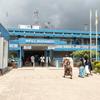 Watu wanaonekana wakiingia kwenye lango kuu la Kituo cha Matibabu cha Weill Bugando, jengo la hospitali ya bluu na nyeupe nchini Tanzania.
